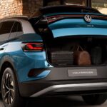 Volkswagen ID.4 Pro: plugue de recarga conectado à lateral de um SUV elétrico em ponto de carregamento urbano.