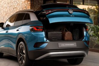 Volkswagen ID.4 Pro: plugue de recarga conectado à lateral de um SUV elétrico em ponto de carregamento urbano.