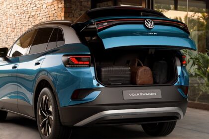 Volkswagen ID.4 Pro: plugue de recarga conectado &agrave; lateral de um SUV el&eacute;trico em ponto de carregamento urbano.